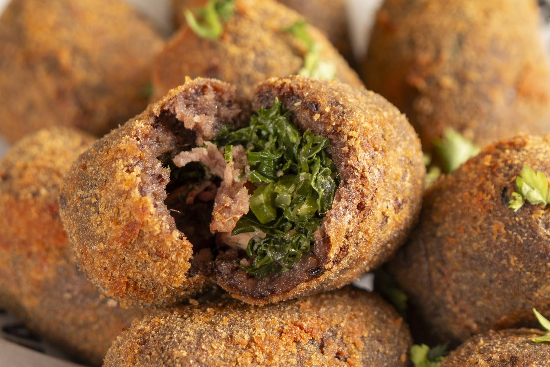 Bolinhos de feijoada abertos, recheados de feijoada e couve